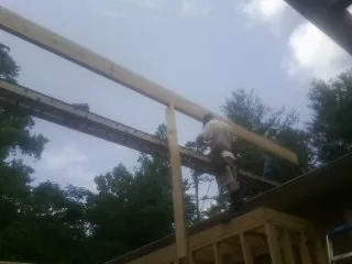 Carpenter setting a ridge beam over a new addition frame — Ice Dam Removal by Roofing Brothers in Michigantown