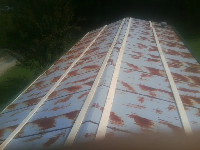 Rusted metal roof panels with new wood purlins before replacement — Storm Damage Roof Repair in Michigantown by Roofing Brothers