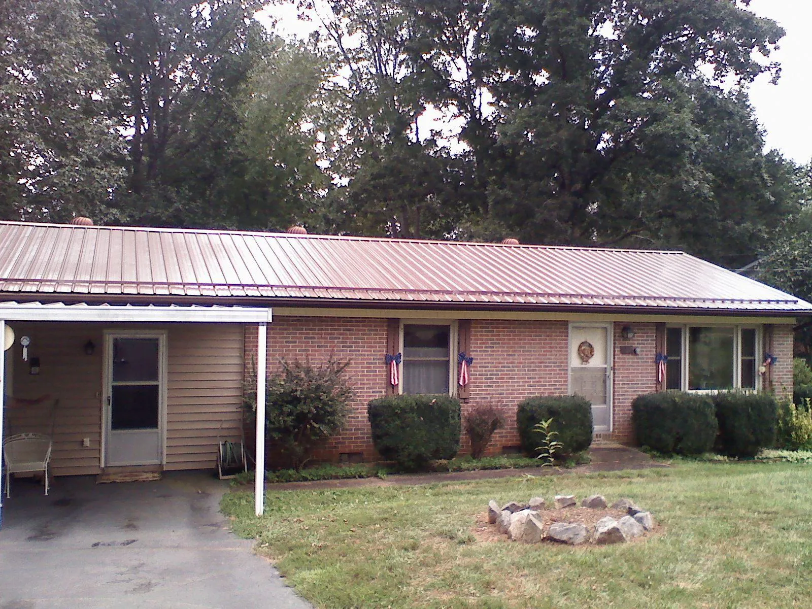 Bronze metal roof and carport on a brick ranch home — Roof Repair work by our crew in Michigantown