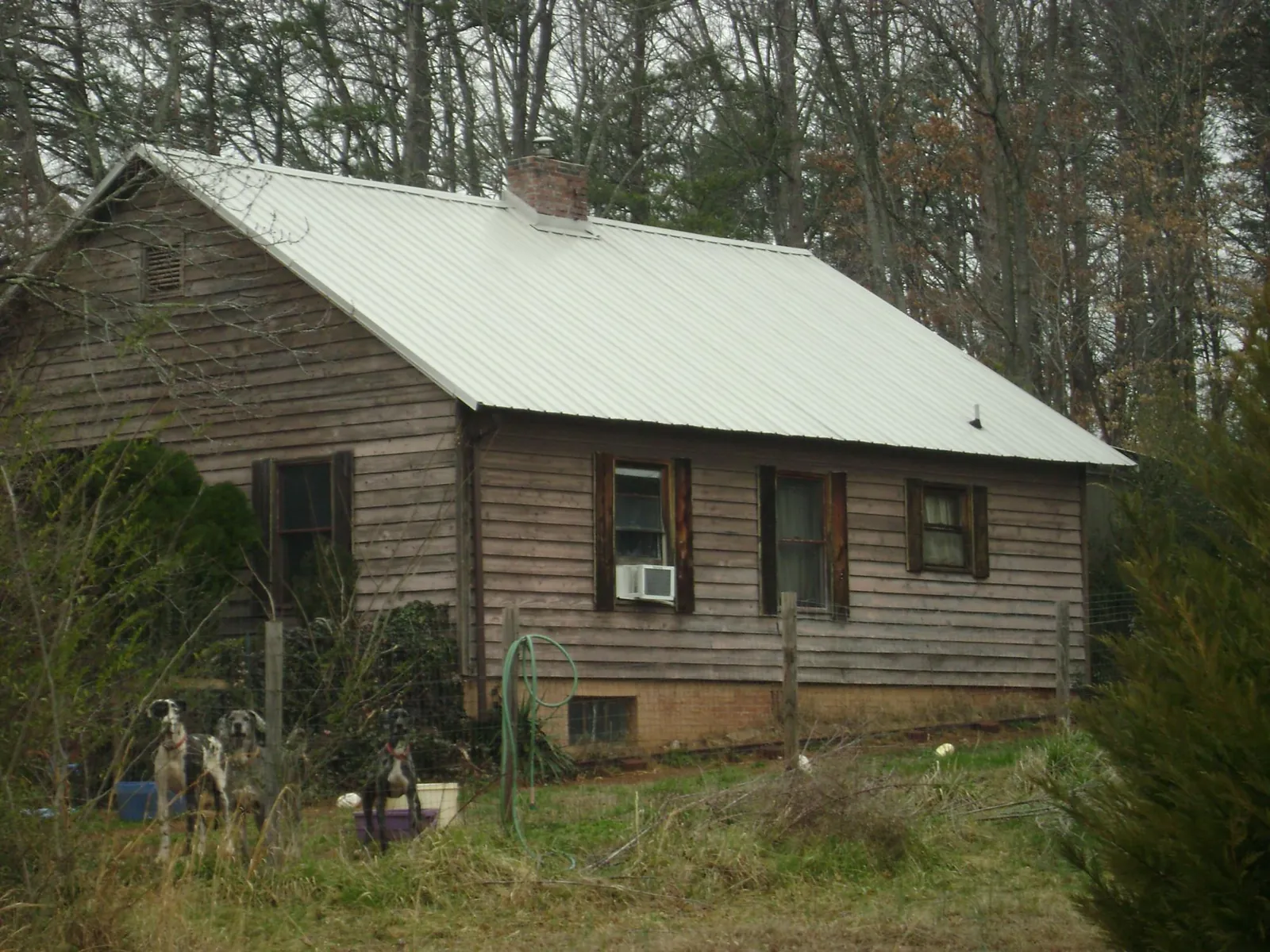 White metal roof on an old wood sided farmhouse, from a Metal Roof Installation job in Michigantown
